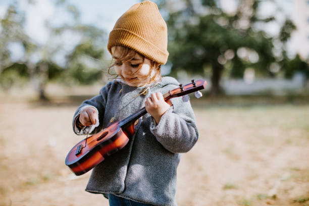 istock Litlle girl playing guitar 1249889962