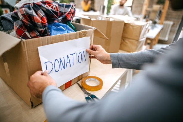 istock Man sticking Donation label to carton box 1249890598