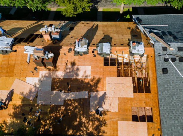 istock Roof repair, worker with replacing gray asphalt tile shingles on house roofing construction worker standing on a roof covering 1249890802