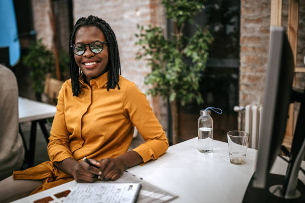 istock Black woman smiling at the camera in office 1249890846