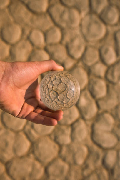istock A glass ball above clay ground 1249895358