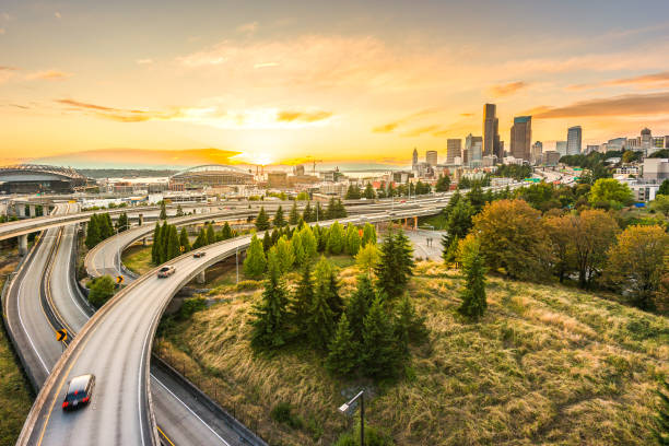 시애틀의 스카이라인과 주간 고속도로는 엘리엇 베이와 일몰 시간, 시애틀, 워싱턴 주, 미국의 해안가 배경과 함께 수렴합니다. - building exterior usa washington state seattle 뉴스 사진 이미지