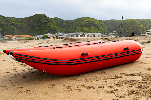 Inflatable boat on the beach red in color