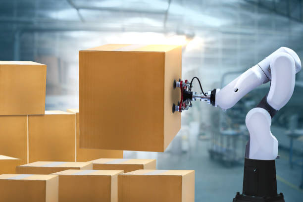 istock Robotic arms carries cardboard box 1249898394