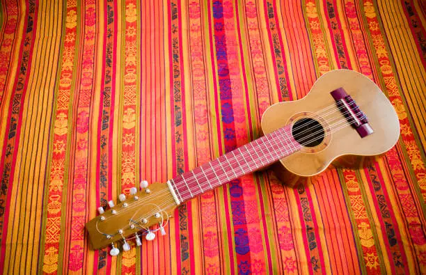 Charango on a colorful Andean pattern blanket background