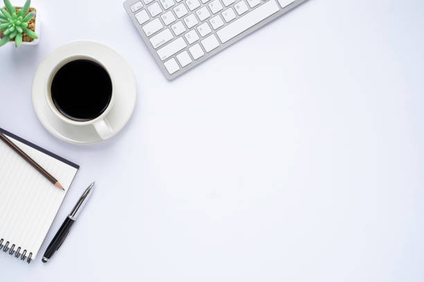 istock White office desk table with keyboard, notebook and coffee cup with equipment other office supplies. Business and finance concept. Flat lay with blank copy space. 1249902347