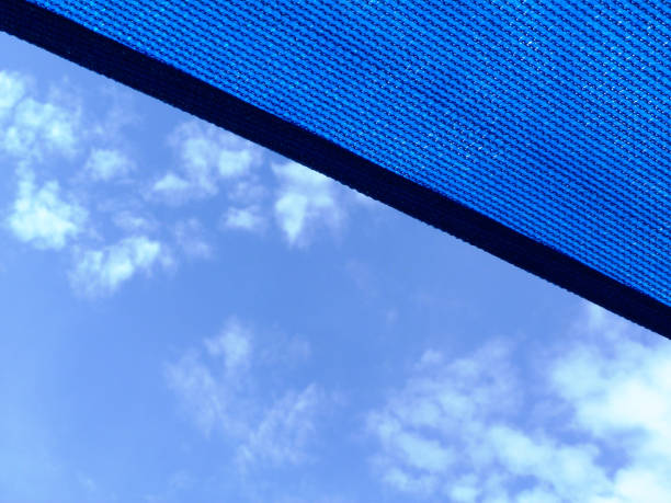 テラスにまたがるゆるく織られた呼吸青い生地のサンシェード素材 - shade sail awning textile ストックフォトと画像