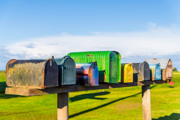 istock Close-up of old multi-colored mailboxes stand on a blackboard in a field 1249908705