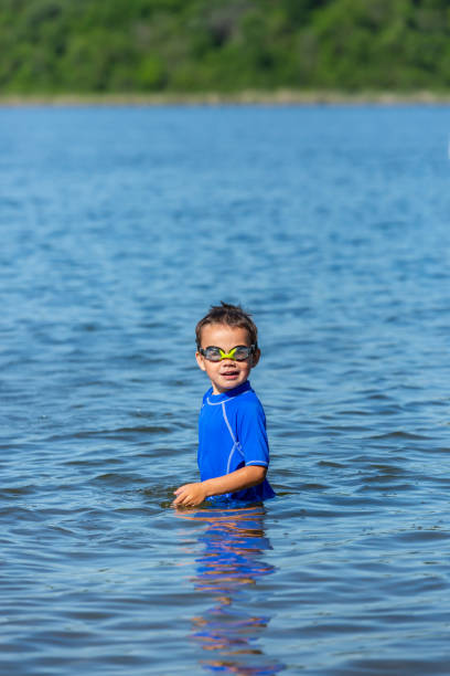 istock Young Boy Standing in Waist Deep Lake Water 1249913234