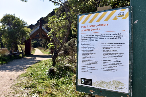 Tasman Region, New Zealand - May 17 2020. A Level 2 Sign at the beginning of the Abel Tasman National Park during the Coronavirus Covid-19 crisis  in New Zealand's South Island. Taken in the Abel Tasman National Park in the Tasman Region, New Zealand.