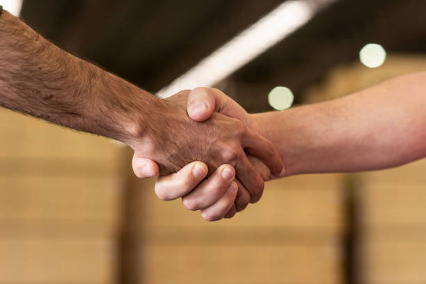 workers handshake at shed factory with wood pile at background - manual worker handshake industry warehouse imagens e fotografias de stock