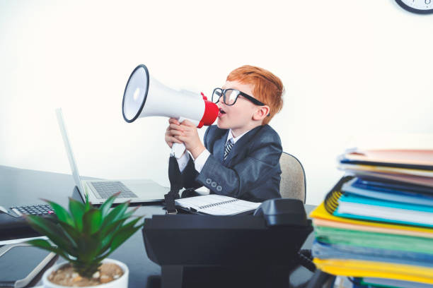 istock Young boy dressed in a suit working at a large desk. 1249920879