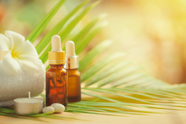 istock Essential oils bottle with towel and candle for aroma spa on nature background, spa set. 1249923600