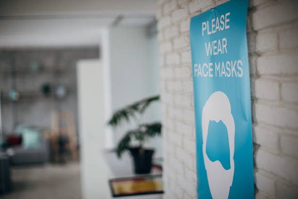 istock Please wear face mask sign on wall in in empty modern office 1249935305
