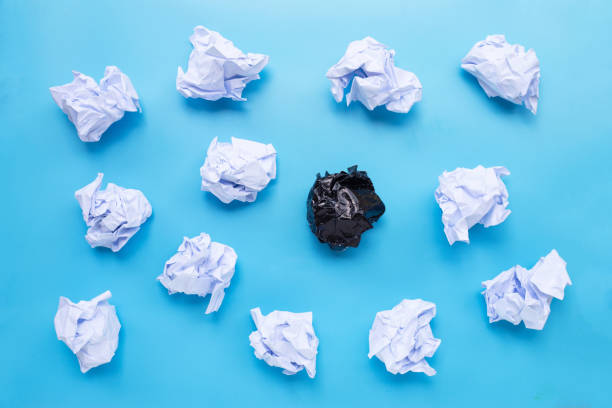 istock White and black crumpled paper balls on a blue background. 1249939186