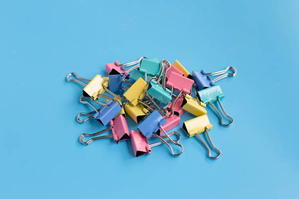 istock Colorful office paper clips on blue background. 1249939258
