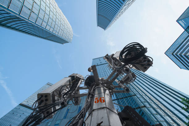 vue à angle bas de la tour de transmission 5g et des gratte-ciel d’affaires modernes dans le centre-ville de la ville moderne pendant le lever du soleil. - high standard photos et images de collection