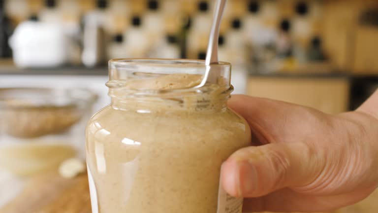 open peanut butter jar and take spoon of  peanut butter