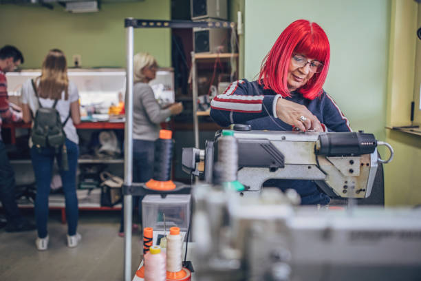 istock Mature woman putting new thread on sewing machine 1249944448