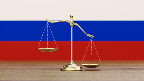 Bronze scale standing in front of Russian flag. Horizontal composition with copy space. Front view. Social justice concept.