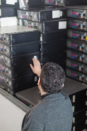 Technician stacking a recycled CPU for donating purposes - portrait