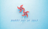 Happy 4th of July Message and Paper Pinwheel Pair Textured with American Flag on Blue Background