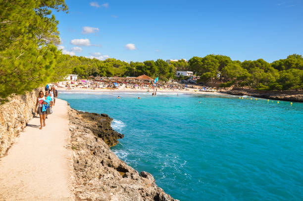 caminho rochoso até a praia de cala mondrago, reserva natural de cala mondrago, ilha de mallorca (majorca), ilhas baleares, espanha. - tree large group of people sand sunbathing - fotografias e filmes do acervo