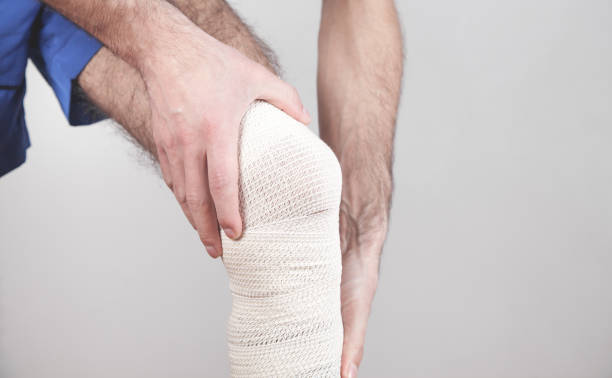 istock Man with a bandage on his injured knee. 1249959979