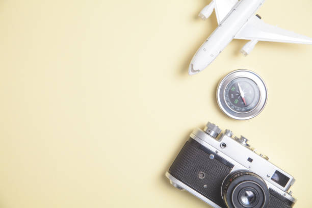 istock Old camera, toy airplane and compass on yellow background. 1249959984
