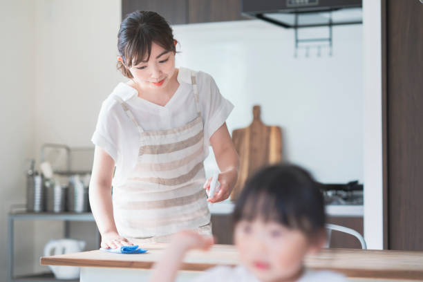 istock Asian woman disinfecting home dining table with spray 1249961078