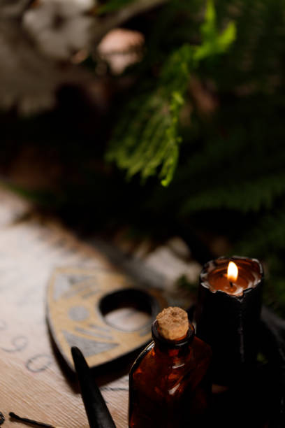 istock Mystic ritual with Ouija and candles. Devil's board concept, black magic or fortune telling rite with occult and esoteric symbols. 1249961087