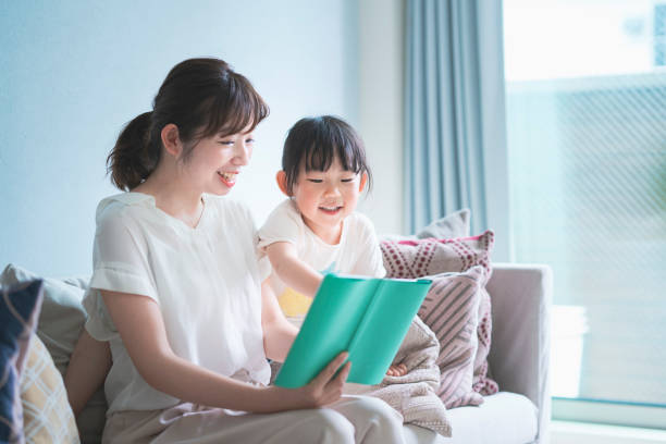 madre e figlia che leggono un libro illustrato - child reading mother book foto e immagini stock