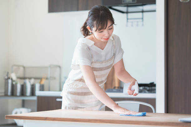 istock Asian woman disinfecting home dining table with spray 1249962417