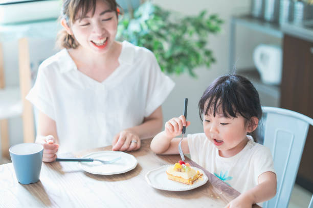 自宅のダイニングテーブルでケーキを食べる - 日本人　親子 ストックフォトと画像