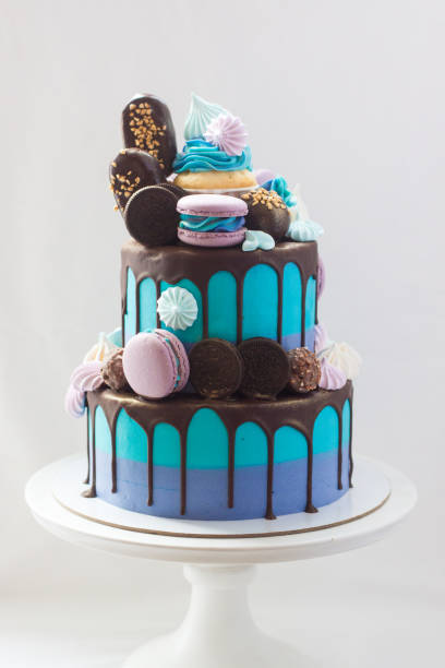 bolo azul em camadas decorado com chocolate escuro, cupcake, biscoitos, macaroons, merengues, picolés e barras de chocolate. - gateaux cake birthday decorating - fotografias e filmes do acervo