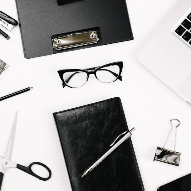 istock Top view white office desk table. Flat lay workspace with eye glasses, laptop, smartphone, clipboard, notebook and a pen, paper clip, pencil, offi supplies on white background 1249967559