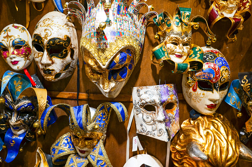 Close up of black and white carnival mask with golden bells at City of Venice on a cloudy summer day. Photo taken August 6th, 2023, Venice, Italy.