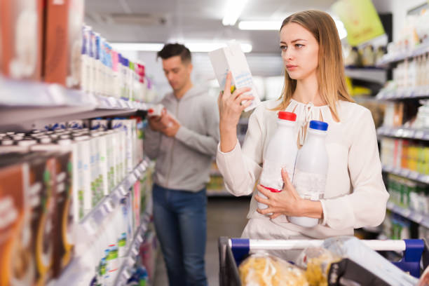 istock Smiling female customer choosing milk 1249969334