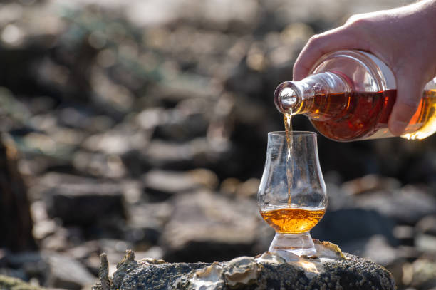 gieten van schotse whisky in proefglas - spey scotland stockfoto's en -beelden