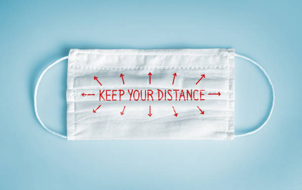 istock Medical face mask with keep your distance message 1249974344