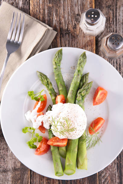 istock asparagus with poached egg and tomato in plate 1249974463