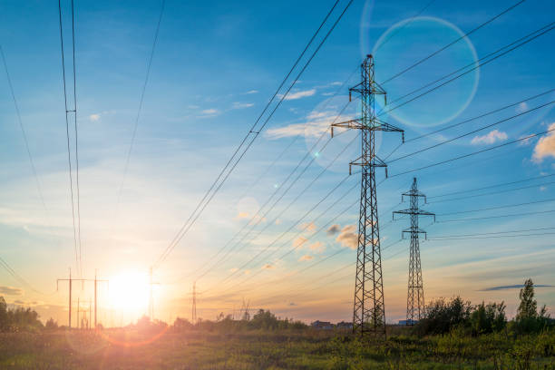 istock Multiple power lines at the sunset with sun flare. Energy distribution and environment 1249974890