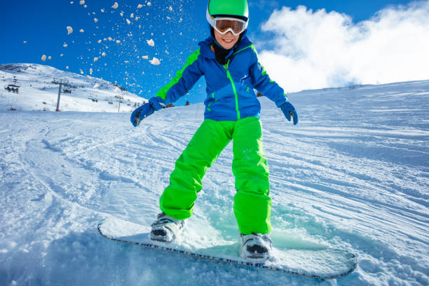 Close portrait of an active boy move fast downhill