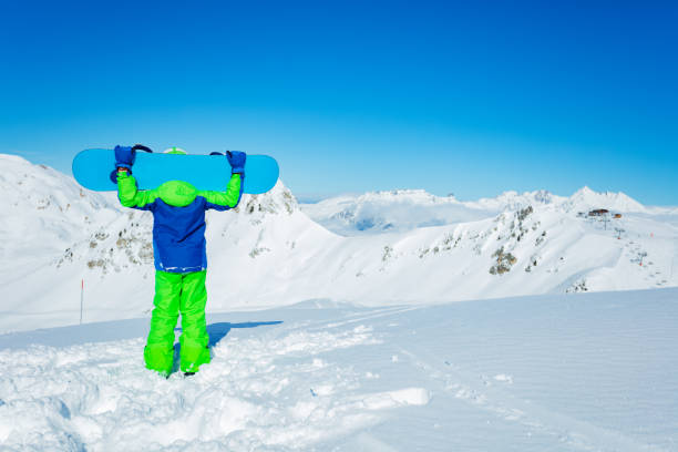 Snowboarder in high mountains during sunny day.