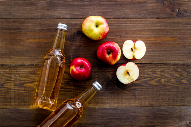 istock Apple cider vinegar bottle on wooden background top view 1249976624