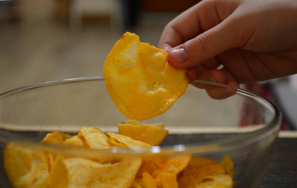 istock female hand takes chips from a bowl 1249976861