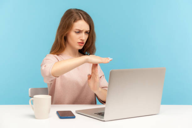 dipendente donna stanco sconvolto che mostra il gesto time out e guarda lo schermo del laptop, parlando in videochiamata - women dependency business time foto e immagini stock