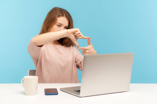 여성 직원, 디자이너 또는 사진 작가, 손으로 사진 프레임을 만들고 노트북 화면에 초점을 맞추고 - trapped computer stuck women 뉴스 사진 이미지