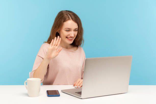 hi! beautiful woman waving hand gesturing hello to laptop screen, talking on video call with friend, communicating online - gesturing interview business sitting imagens e fotografias de stock