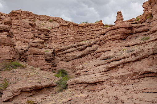 Strange rock formations in a canyon with storm clouds overhead